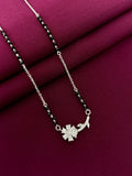 Silver mangalsutra with a floral pendant on a purple fabric background