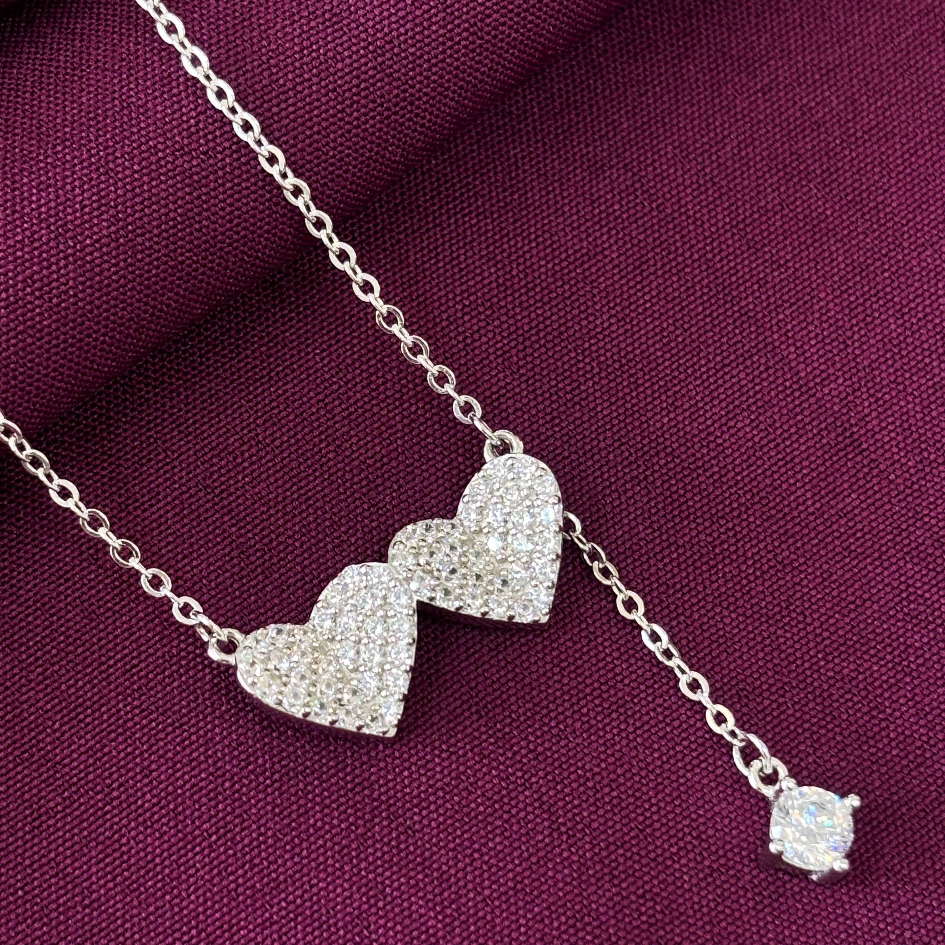 Silver necklace with a pendant on a purple fabric background