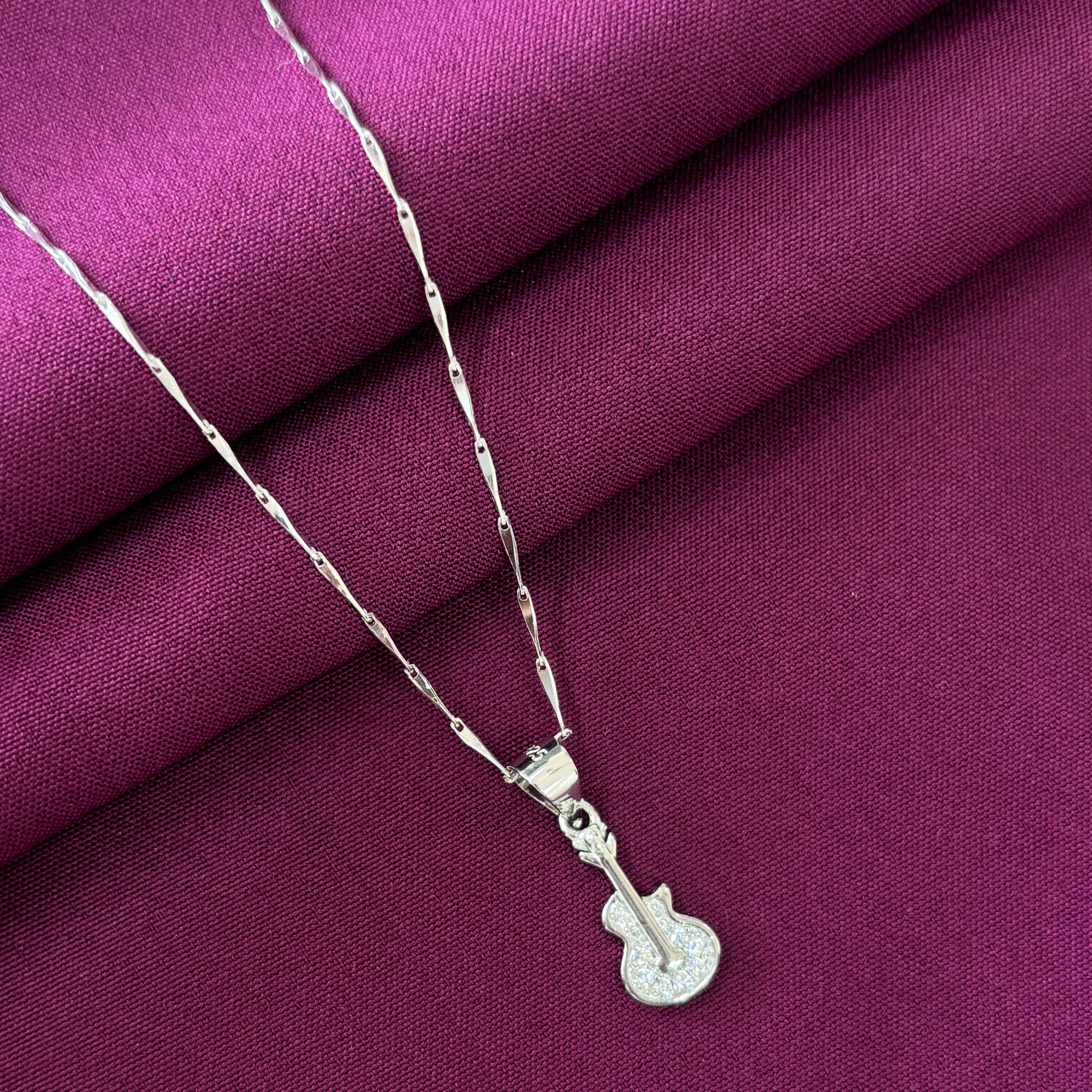 Silver necklace with a pendant on a purple fabric background