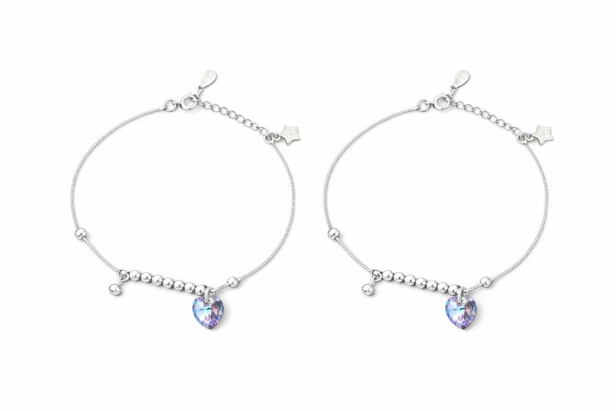 Two silver payal with heart-shaped gemstones on a white background