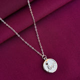 Silver necklace with a round pendant on a purple fabric background