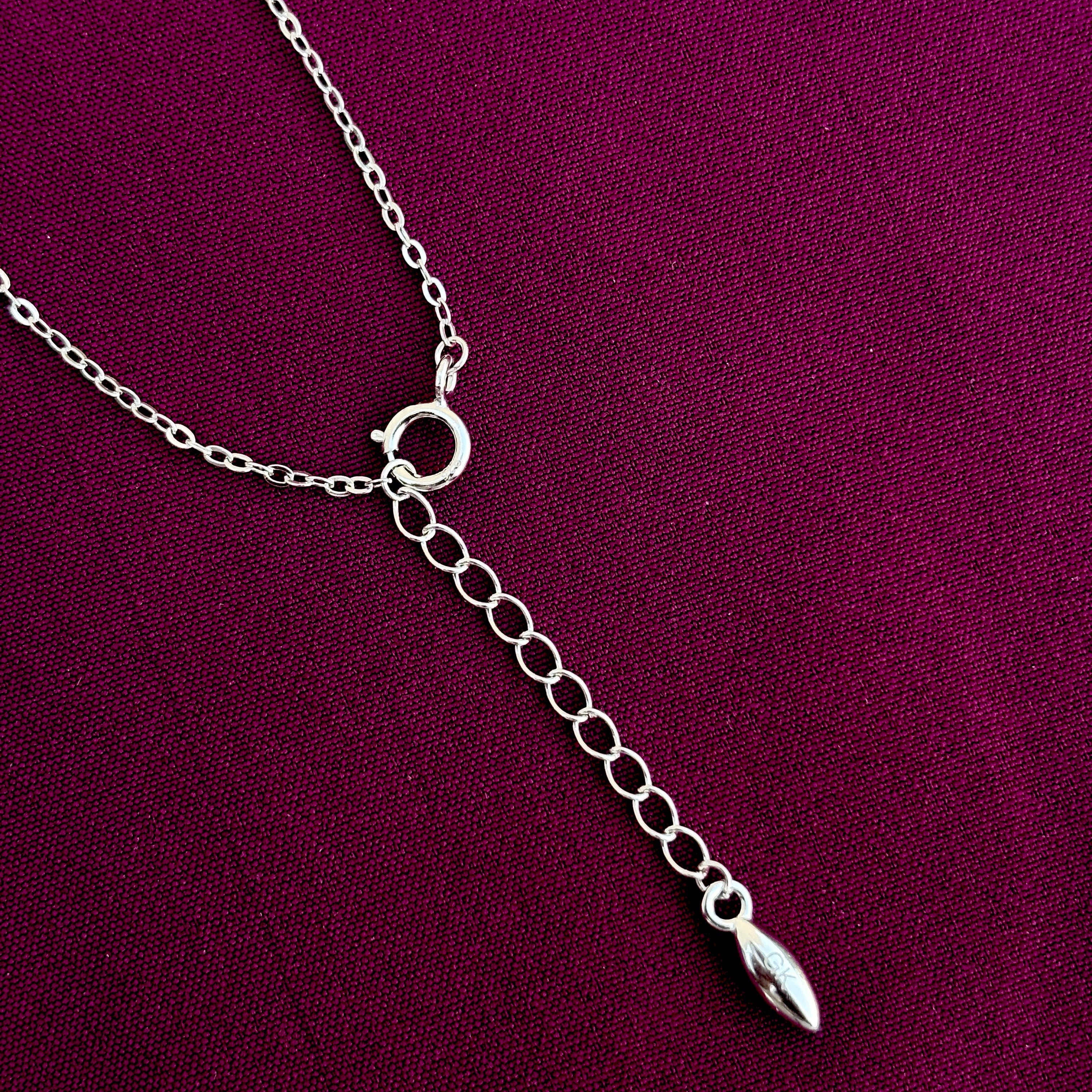 Silver necklace with a pendant on a purple background
