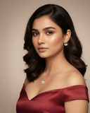 Woman wearing a red off-shoulder dress with jewelry on a neutral background