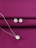 Silver jewelry set with earrings and a necklace on a purple fabric background