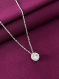 Silver necklace with a round pendant on a purple fabric background