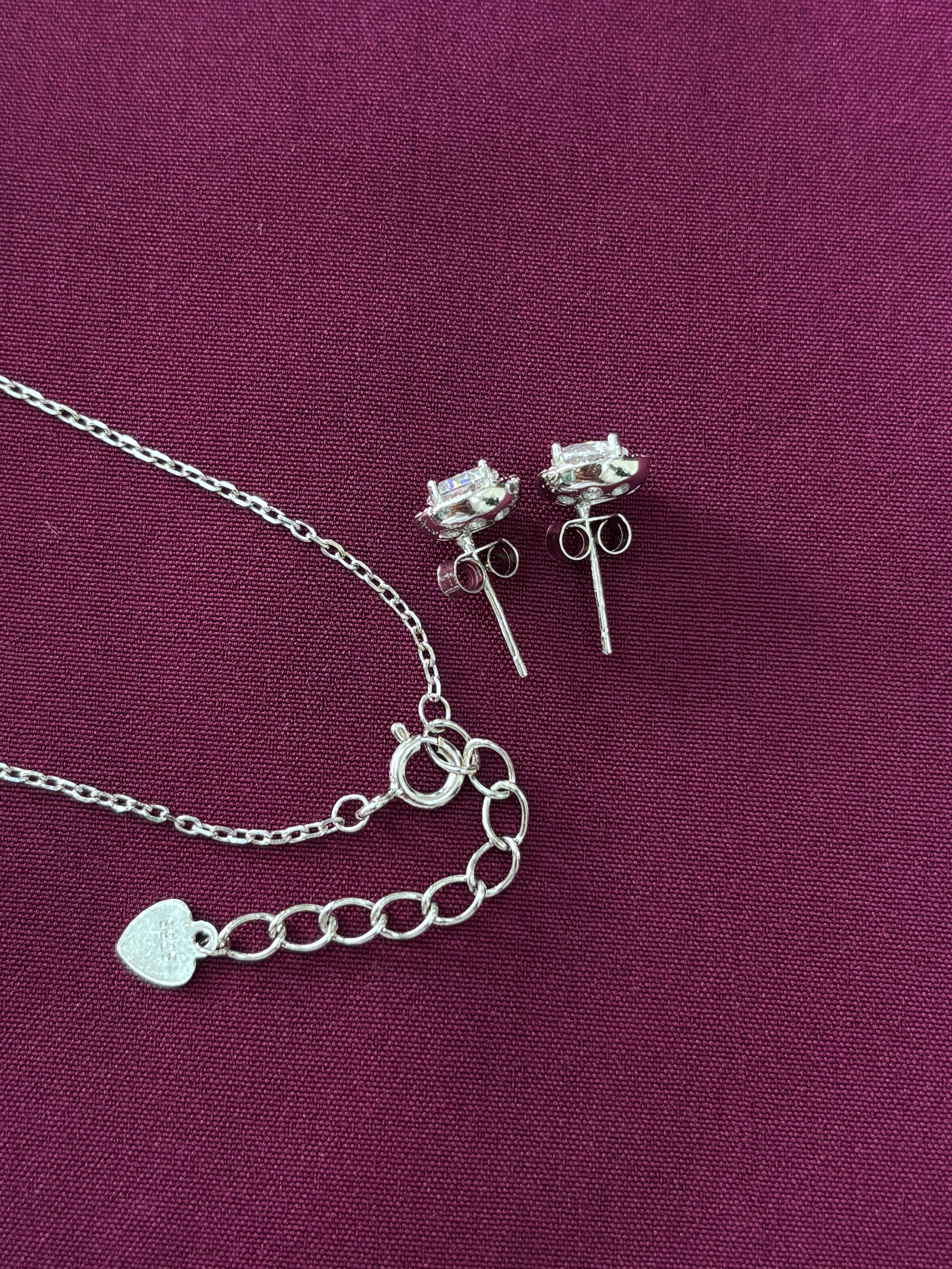 Silver earrings with chain on a purple background