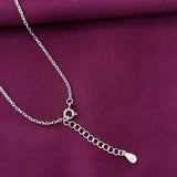 Silver chain necklace on a purple fabric background