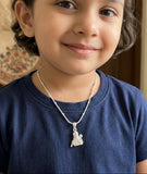 Child wearing a blue shirt with a necklace featuring a silver pendant