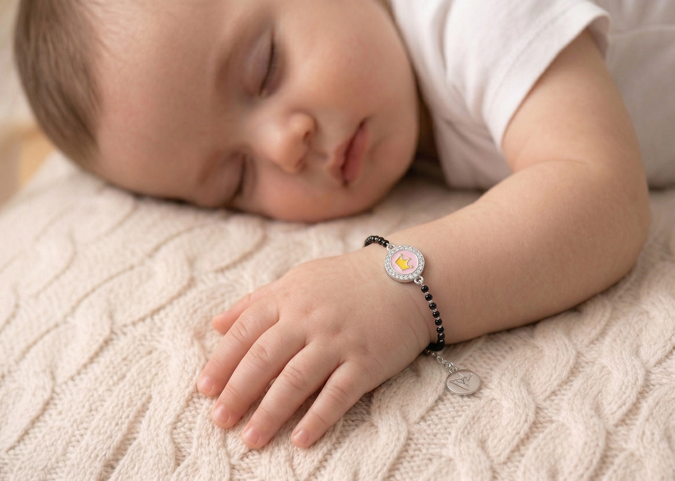 Child sleeping with a bracelet on a textured surface