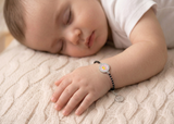 Child sleeping with a bracelet on a textured surface