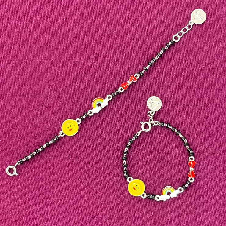 silver Bracelet with smiley face charms on a pink background