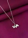 Silver necklace with a small elephant pendant on a purple fabric background
