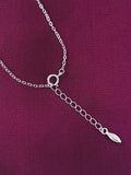 Silver chain pendent on a purple fabric background