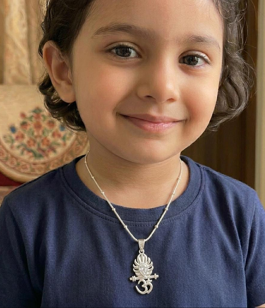 Child wearing a blue shirt and silver necklace with a pendant