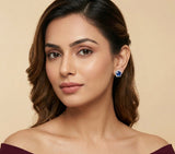 Woman wearing a star-shaped earring against a beige background