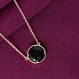 Necklace with a black pendant on a purple fabric background