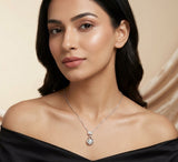Woman wearing a silver necklace with a pendant against a beige background
