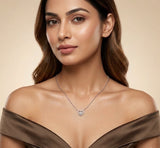 Woman wearing a silver necklace with a heart pendant against a beige background