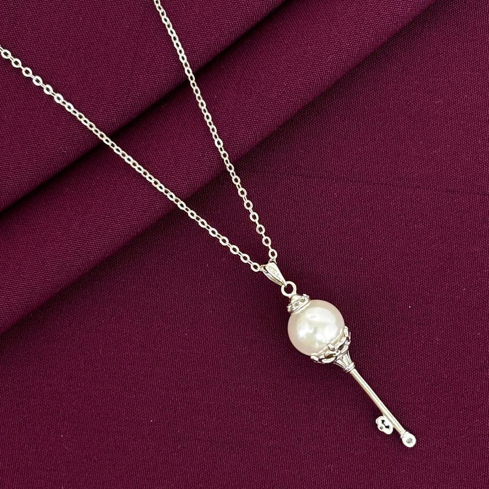 Silver necklace with a pearl pendant on a purple fabric background