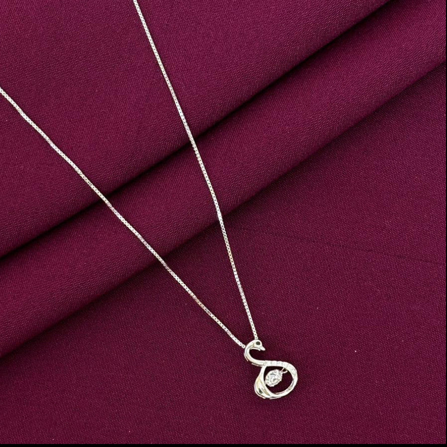 Silver necklace with a pendant on a purple fabric background