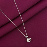 Silver necklace with a pendant on a purple fabric background