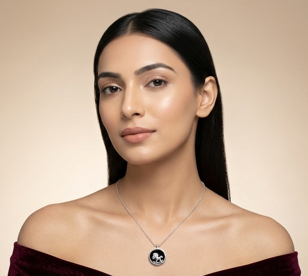 Woman wearing a necklace with a black pendant against a beige background