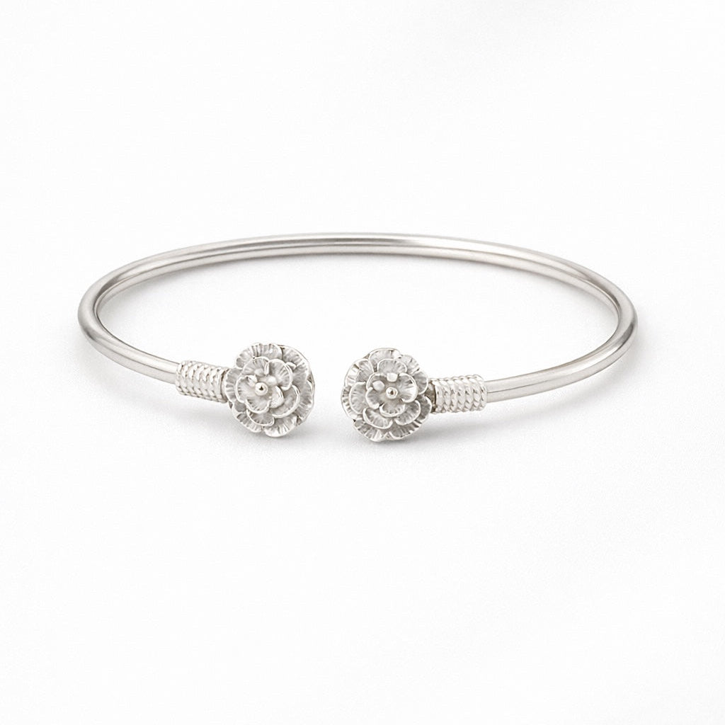 Silver bracelet with floral charm on a white background