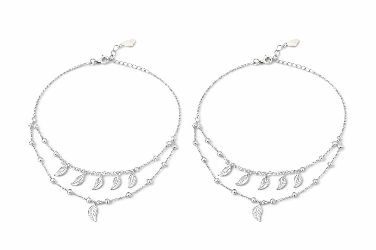 Two silver layered anklet with leaf-shaped charm on a white background