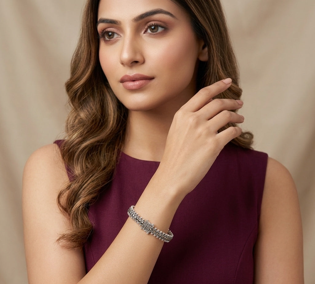 Woman wearing a purple dress and bracelet against a beige background
