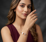 Woman wearing a gold bracelet on a dark background