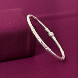 Silver bracelet on a purple fabric background