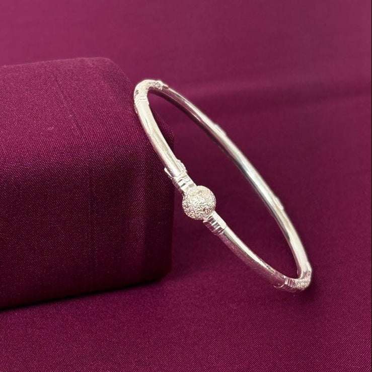 Silver bracelet on a purple fabric background