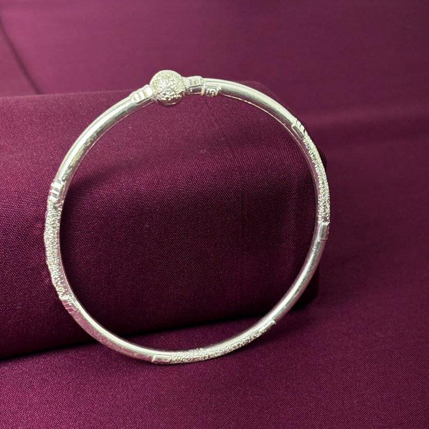 Silver bracelet on a purple fabric background