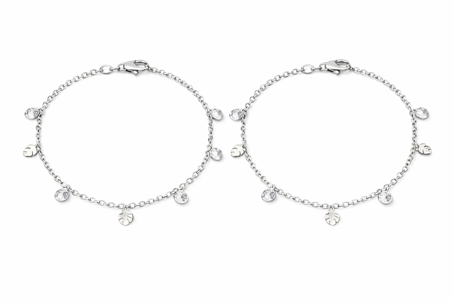 Two silver anklets with small round charms on a white background