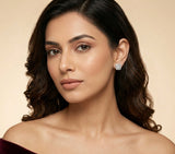 Woman wearing a diamond earring against a beige background