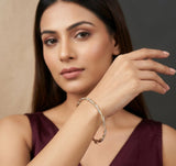Woman wearing a silver bracelet on a neutral background